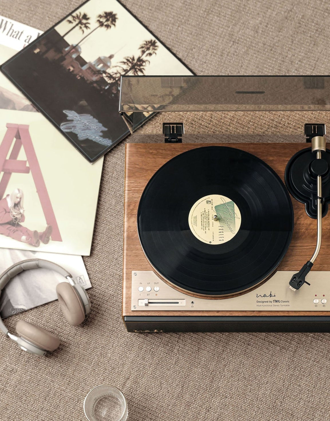 Tinyl WABI all-in-one record player featuring a minimalist wood-grain finish and sleek metal panel design. A high-power 100W Hi-Fi turntable built for Zen home decor aesthetic.
